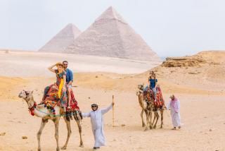 Travellers crossing a desert landscape